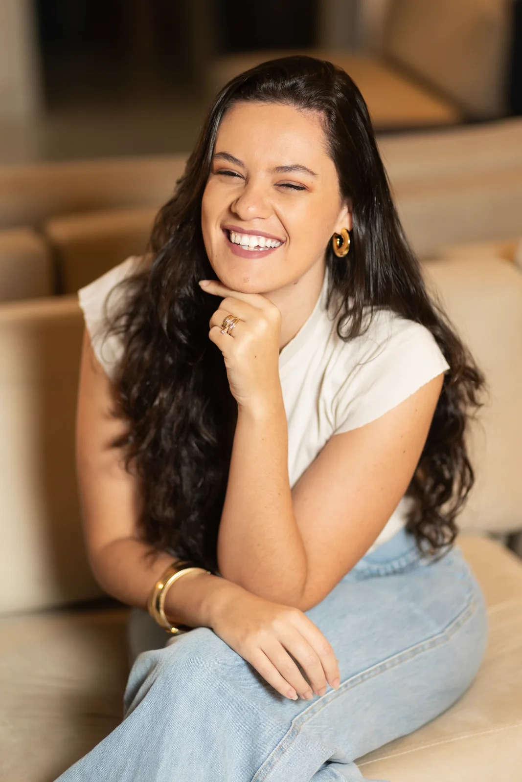 Raquel sorrindo, com a mão no queixo